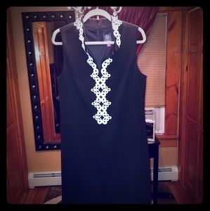Black dress with simple white trim.
